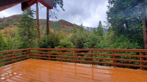 a wooden deck with a view of the mountains at Redwood Retreat, Mountains, Adventure and Nature in Ponderosa