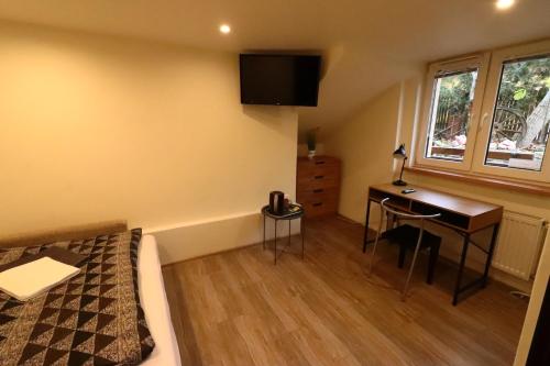 a bedroom with a bed and a desk and a bed and a window at Karczma Pod Jesionem in Brdów