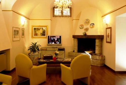 a living room with yellow chairs and a fireplace at Deco Hotel in Perugia