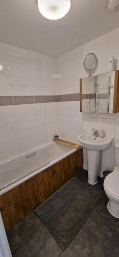 a bathroom with a tub and a toilet and a sink at Norwich, Lavender House, 3 Bedroom House, Private Parking and Garden in Norwich
