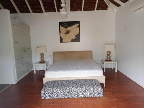 Un dormitorio con una cama y dos mesitas de noche. en Solwata House, On the Water Sleeps 6, en Port Vila