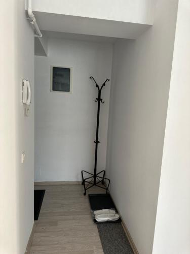 a room with a white wall with a tripod in it at Fly Airport Residences & Therme-SELF CHECK-IN in Otopeni