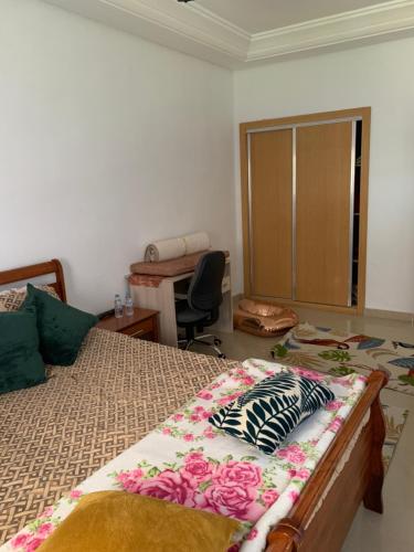 um quarto com uma cama, uma secretária e uma cadeira em Sidi rahel em Casablanca