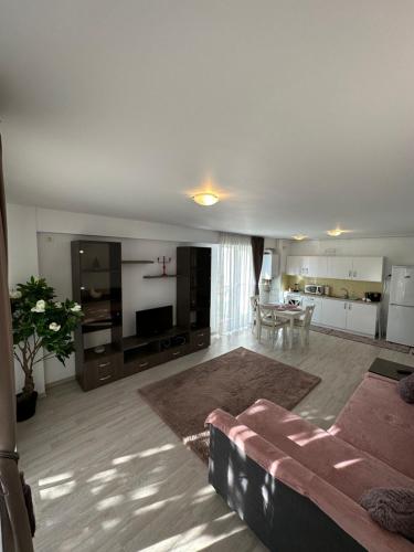 a living room with a couch and a table at Fly Airport Residences & Therme-SELF CHECK-IN in Otopeni