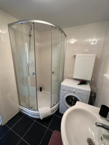 a bathroom with a shower and a washing machine at Fly Airport Residences & Therme-SELF CHECK-IN in Otopeni