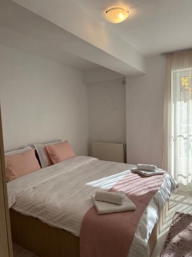 a bedroom with a large bed with two towels on it at Fly Airport Residences & Therme-SELF CHECK-IN in Otopeni