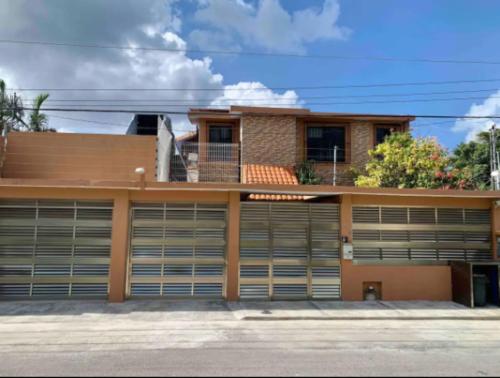 dom z dwoma drzwiami garażowymi przed nim w obiekcie Casa Real Cozumel w mieście Cozumel