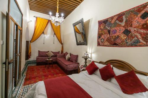 een slaapkamer met een bed en een bank bij Charmant appartement avec terrasse privee a fes medina in Fès