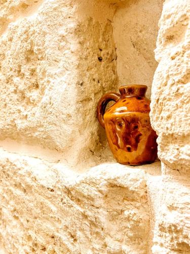 a brown vase sitting in a stone wall at PALAZZO CAVÌ in Mola di Bari