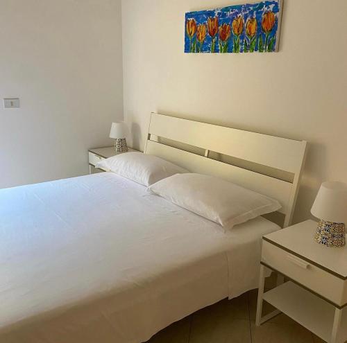 a bedroom with two beds and a painting on the wall at Carolina Apartments - I° Piano in Capo dʼOrlando