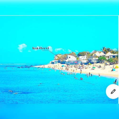 a view of a beach with people in the water at Villa Maimouna les pieds dans l'eau in Saint-Pierre