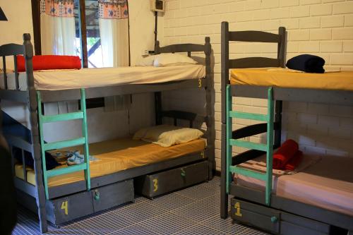 a room with three bunk beds in a room at Praia do Rosa Hostel in Praia do Rosa