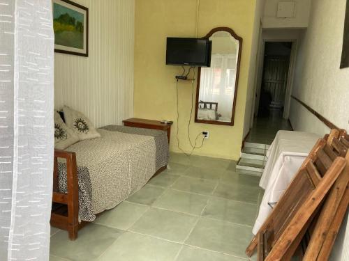 Habitación pequeña con cama y espejo. en Lo de IRMA, en Piriápolis