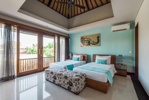 レギャンにあるVilla Lacasa2- modern tropical 2BR Villa with butlerのベッドルーム1室(ベッド2台付)、バルコニーが備わります。