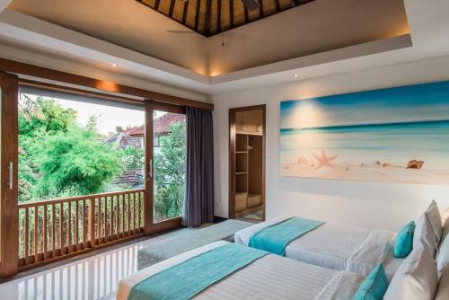 a bedroom with two beds and a balcony at Villa Lacasa3 -Modern tropical 3BR Villa with butler in Legian