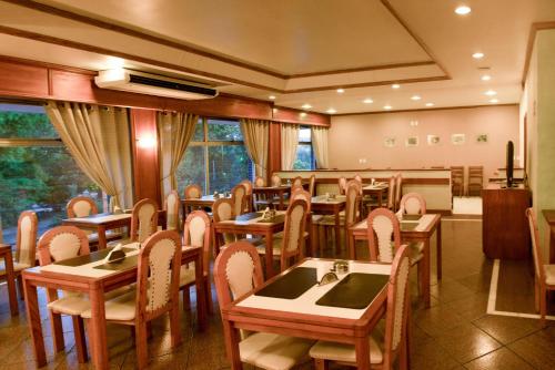 a restaurant with wooden tables and chairs in a room at Hotel Atlantico Rio Grande in Rio Grande