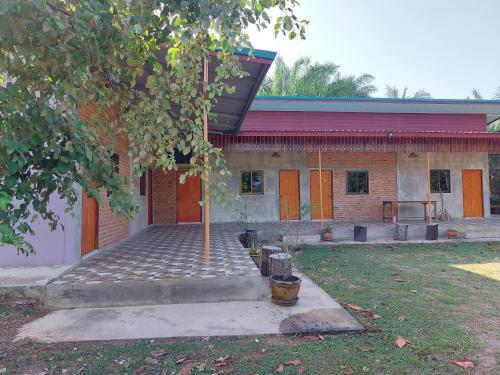 uma casa com uma árvore em frente em Yoga Homestay Seka em Seka
