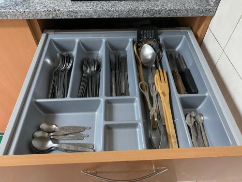 a tray with utensils in a kitchen drawer at Casa Violeta in Águeda