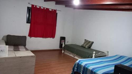 1 dormitorio con cama y cortina roja en La Plata C en La Plata