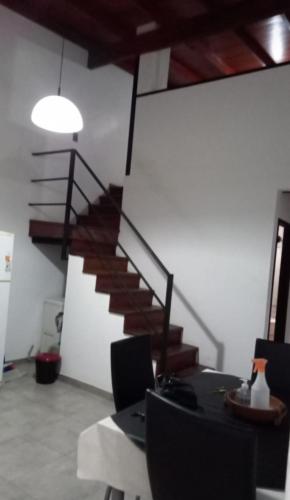 Habitación con escalera y mesa con sillas. en La Plata C en La Plata