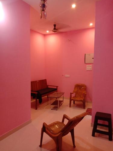 a room with chairs and a pink wall at Thendralhomestay in Puducherry
