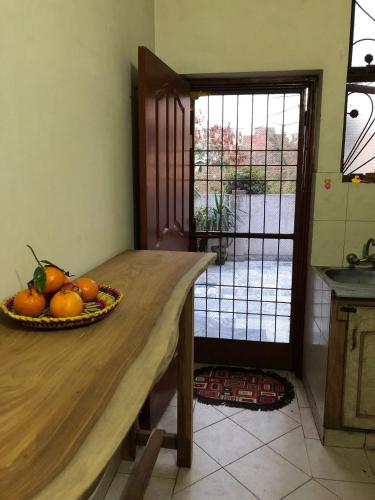 Five Giants Lahore Homestay في لاهور: وعاء من البرتقال على طاولة خشبية في مطبخ