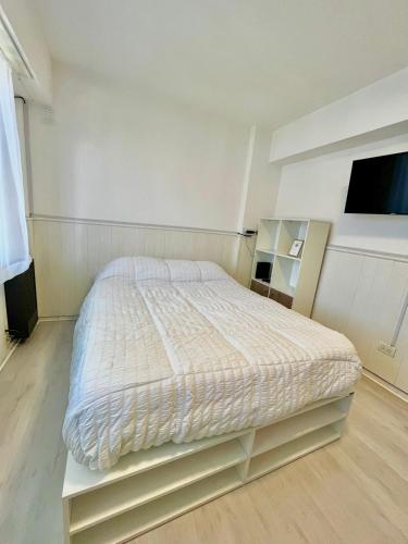 1 dormitorio blanco con 1 cama y TV en Studio en Mar del Plata