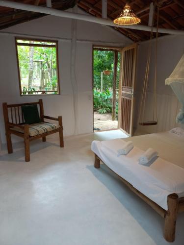 a room with two beds and a bench in it at Sitio Namaste in Itacaré