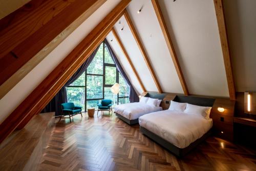 En eller flere senge i et værelse på KanollyResorts Hakuba