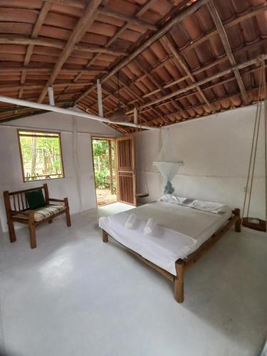 1 dormitorio con 1 cama y 1 silla en Sitio Namaste, en Itacaré