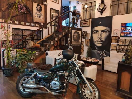 a motorcycle parked in a room with pictures on the wall at Hotel el Che No apto para corruptos in Azogues