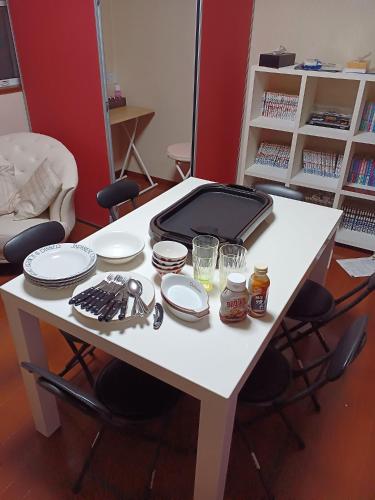 a white table with dishes and a suitcase on it at 白浜 Mizuki-ya in Kamitondacho