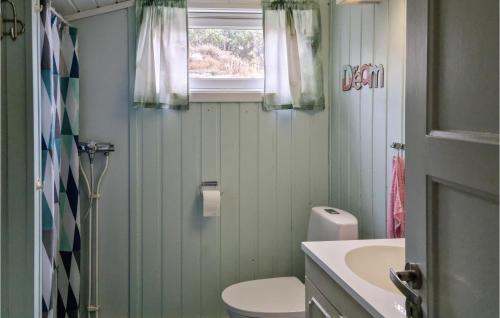 uma casa de banho com um WC, um lavatório e uma janela em 3 Bedroom Nice Home In Spangereid em Spangereid