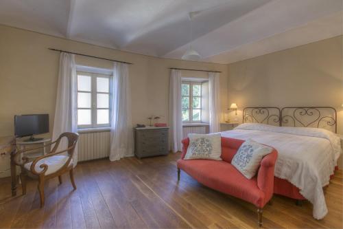 a bedroom with a bed and a chair and a desk at Marchesi Alfieri - Cantine e Ospitalità in San Martino Alfieri