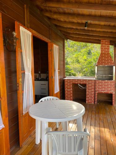 a white table and chairs on a wooden deck at CASA GAMBOA BEACH in Garopaba