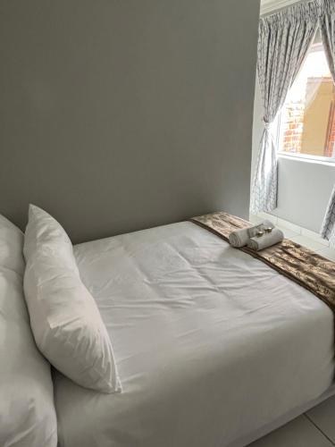Una cama o camas en una habitación de 14th On Clifford Guest House