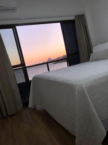 a bedroom with a bed and a view of the ocean at Hotel Espadarte in Iriri