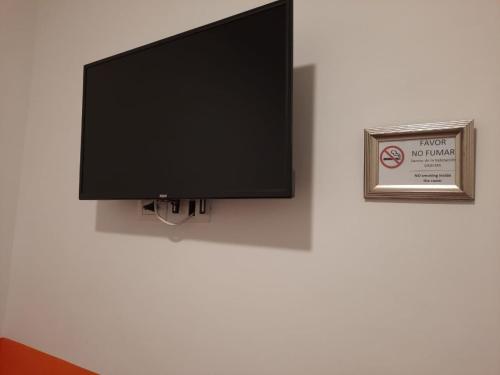 a flat screen tv hanging on a wall at Tequila Sunrise Hostel in Guatemala