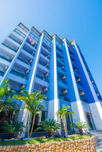 a blue building with palm trees in front of it at Hotel Espadarte in Iriri