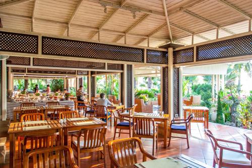 a restaurant with wooden tables and chairs and people in it at Mission Hills Phuket Golf Resort-SHA Extra Plus in Por Bay