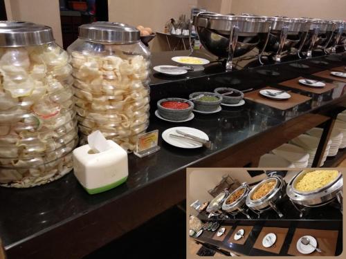 a buffet with jars of food on a table at Olympic Hotel in Jakarta