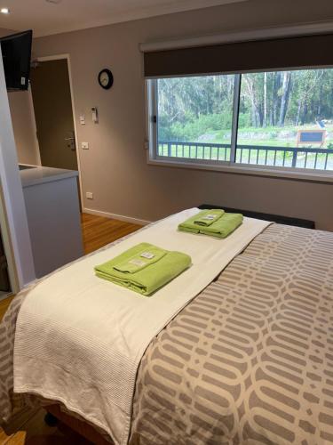 a bedroom with a bed with two green towels on it at Sinclairs Country Retreat - Welcoming Guests 18 years and older in Conjola