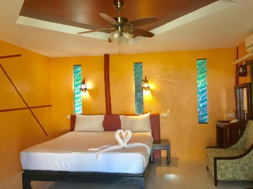 a bedroom with a bed and a ceiling fan at Lamai chalet in Amphoe Koh Samui