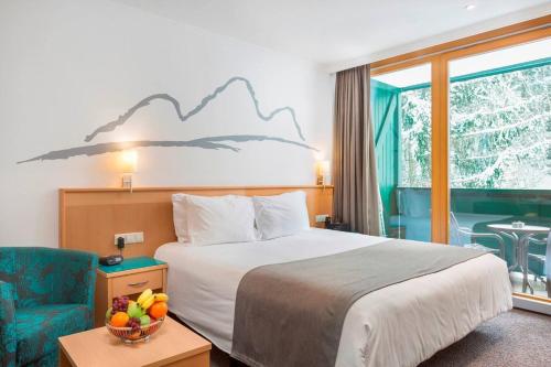 a hotel room with a bed and a chair at Alpine Club Apartement für 6 Personen in Schladming