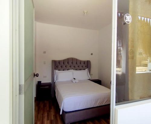 a small bedroom with a bed with white sheets at Hospedaje EL MARQUEZ Expat in Máncora