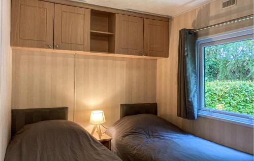 two beds in a small room with a window at 3 Bedroom Stunning Home In Heinkenszand in Heinkensand