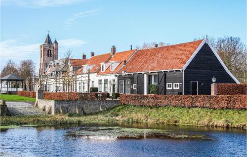 a building next to a river with a church at 3 Bedroom Stunning Home In Heinkenszand in Heinkensand