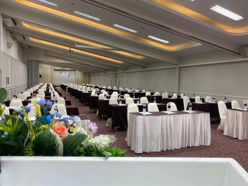 un gran salón de banquetes con mesas, sillas y flores en Brighton Hotel, en Bangkok