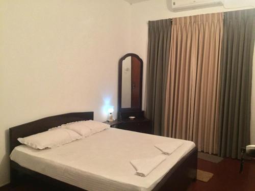 a bedroom with a bed with a mirror and a dresser at Galle Rest Home in Galle