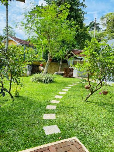 a stepping stone path in a yard with trees at Birdsong Villa in Rathgama
